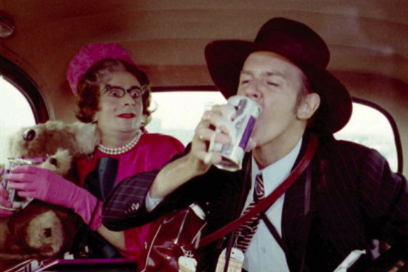Humphries as Aunty Edna with Barry Crocker in a London taxi in a scene from <i>The Adventures of Barry McKenzie.