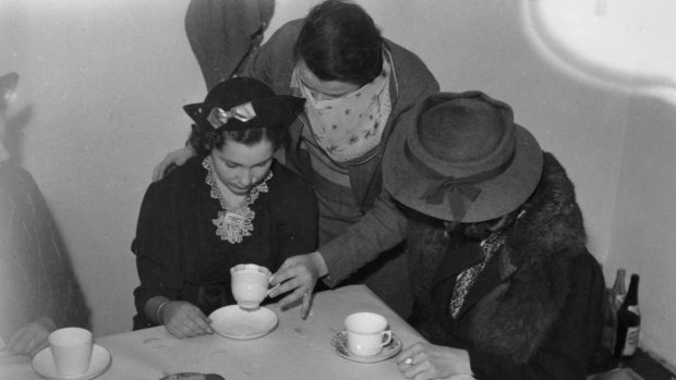 A photo taken in 1938 of teacup readings in Brisbane were illegal under Queensland's criminal code so they were done in secret.