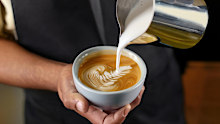 Barista making a cup of coffee latte art