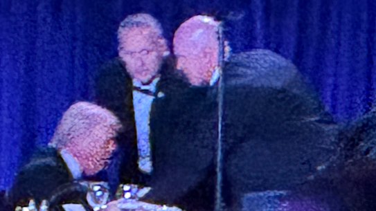 O presidente dos EUA, Donald Trump, antes de ser retirado do palco.