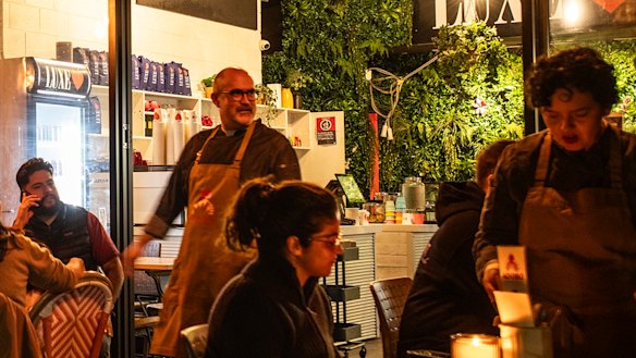 Luis Arana, second from left, and Andrea Tenorio, far right, serving tables while Adobo Tacos is in operation