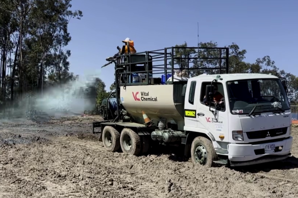 A Vital Chemical truck sprays its hydromulch on bare earth at a work site.