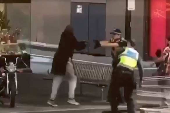 Police officers confront Hassan Khalif Shire Ali on Bourke Street last year. 