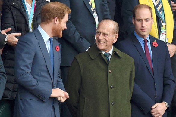 From left: Prince Harry, his late grandfather Prince Philip, and Prince William attend the Rugby World Cup final match between New Zealand and Australia in London in 2015.  