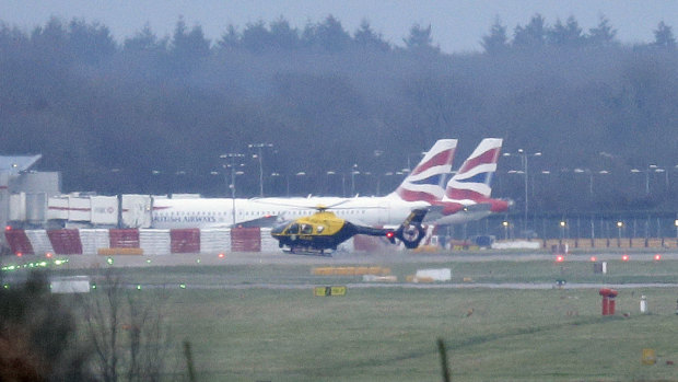 A police helicopter flies over Gatwick Airport on Thursday. Police played cat and mouse with the drone.