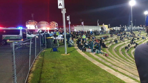 Ambulance officers attending to two people who were shot at Perth Motorplex on Saturday night.