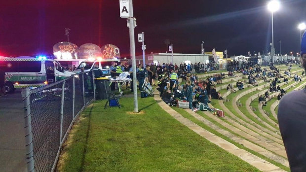 Ambulance officers attending to two people who were shot at Perth Motorplex on Saturday night.