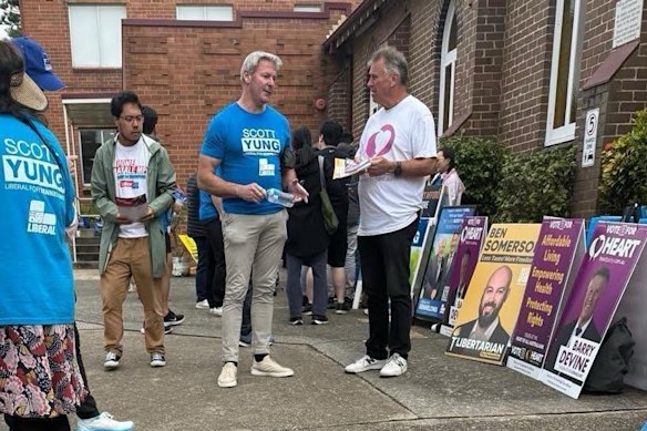 Gareth Hales (centre, in blue T-shirt), multimillionaire son of Plymouth Brethren Christian Church leader Bruce Hales at the Bennelong polling booth on April 30.