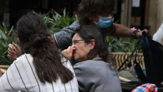 A waitress checks clients’ health passes at a restaurant in Paris, Monday Aug.9, 2021. People in France are now required to show a QR code proving they have a special virus pass to enjoy restaurants and cafes or travel across the country. The measure is part of a government plan to encourage more people to get the vaccine and to slow down a surge in infections, as the highly contagious delta variant now accounts for most cases in France.(AP Photo/Adrienne Surprenant)