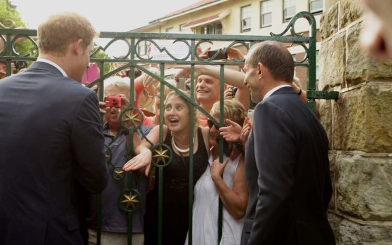 Prince Harry and former prime minister Tony Abbott greet wellwishers at the gate to Kirribilli House.
