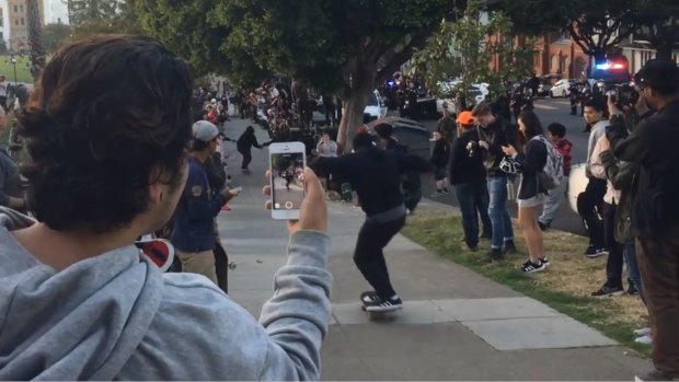 Skateboarders move the informal competition to a footpath, away from a tense standoff with police on the road.