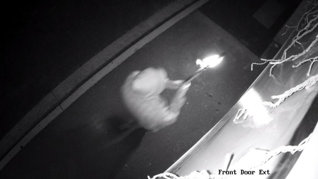 A person holds a flaming object, which was lobbed into Jenny Magic Massage in Phillip on Tuesday night.