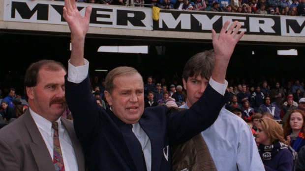 Ted Whitten, supported by his son (left) and Frawley (right), waves to the MCG crowd at the 1995 State of Origin clash.