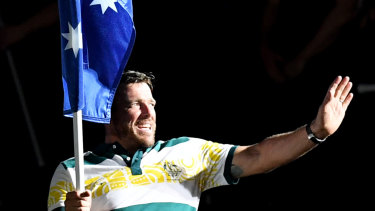 Kurt Fearnley carries the Australian flag into the closing ceremony.