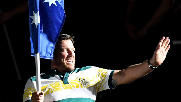 Kurt Fearnley carries the Australian flag into the closing ceremony.