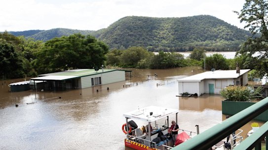 Patricia Parker, 86, views her submerged home from the safety of her son and daughter-in-law's balcony at Nagles Gully, on the Hawkesbury River where the flood waters continue to rise near Wisemans Ferry. 24th March 2021 Photo: Janie Barrett