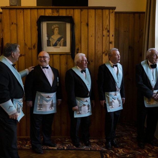 Mason members gather before their monthly dinner at the Kensington Masonic Hall where a portrait of Queen Elizabeth II hangs. 