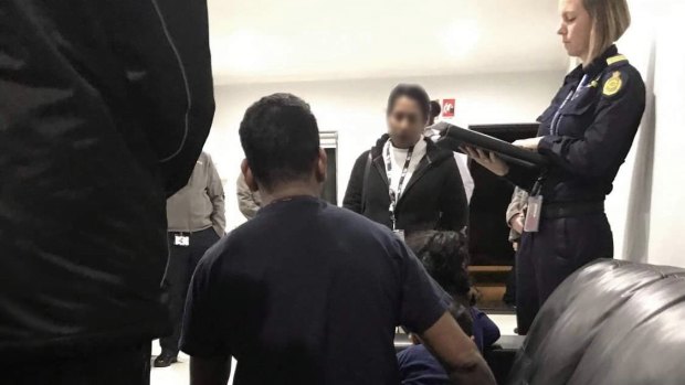 An Australian Border Force official with Tamil asylum seeker father Nadesalingam and one of his children at MITA on Thursday night.