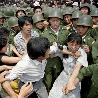 A young woman is caught between civilians and Chinese soldiers, who were trying to remove her from an assembly near the Great Hall of the People the day before the massacre.