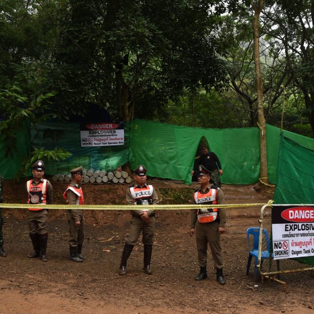 Thai police guard the entrance to the track leading to Tham Luang cave.