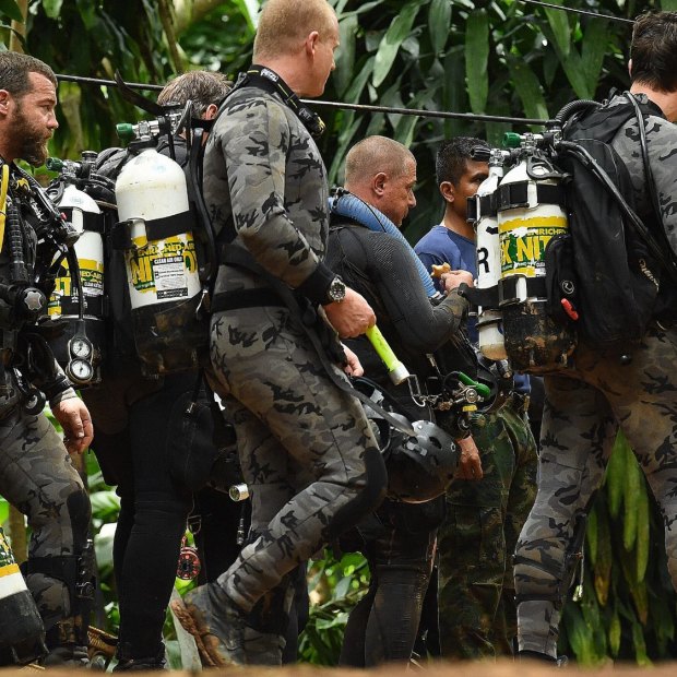 Members of the Australian dive team walk down the track that leads to the cave entrance on July 5. 