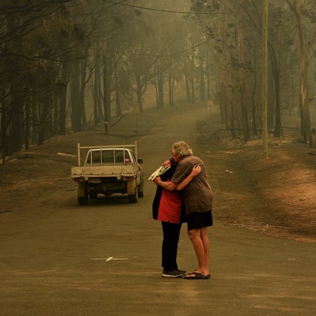 Residents comfort each other on Runniford Road in Nelligen where several homes were destroyed in January 2020.
