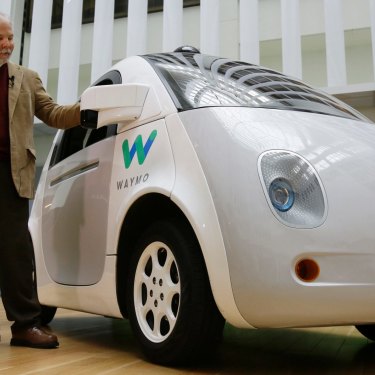 Steve Mahan, who is blind, stands by the Waymo driverless car during a Google event, 