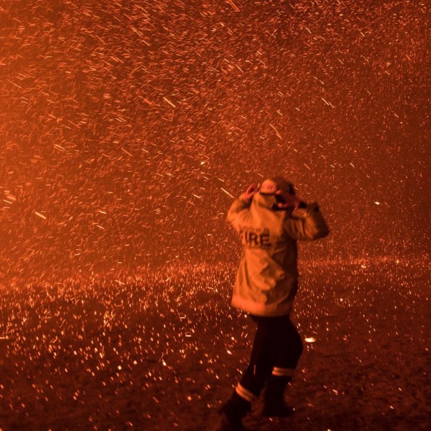 Firefighters run for safety as the Green Wattle Creek fire explodes 
from the bush in Orangeville, NSW, in December.