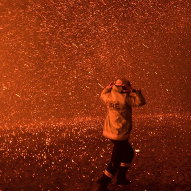 Firefighters run for safety as the Green Wattle Creek fire explodes 
from the bush in Orangeville, NSW, in December.