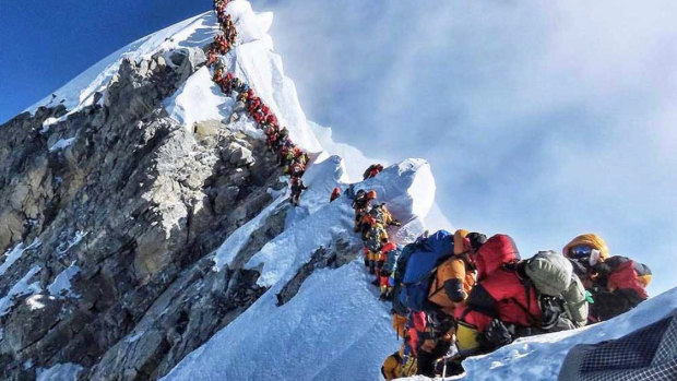 Mountain climbers lining up to stand at the summit of Mount Everest this climbing season.