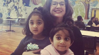 Two Australian-born children of Tamil asylum seekers with an unknown woman at Melbourne airport. The family has been saved from deportation by a last-minute injunction.