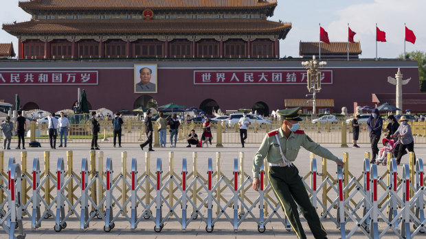 A member of the People’s Armed Police sets up barriers in Tiananmen Square ahead of the national flag lowering ceremony. 