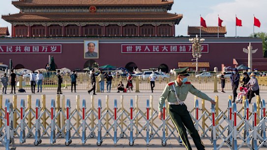 A member of People’s Armed Police pulls extensible barrier in the Tiananmen Square to get ready for the national flag lowering ceremony. 