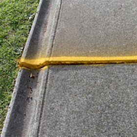 A woman tripped and fell on this uneven section of a footpath in a large regional council. She was knocked out, injured her face, broke her glasses and was taken to hospital as a result of the July 2023 fall.