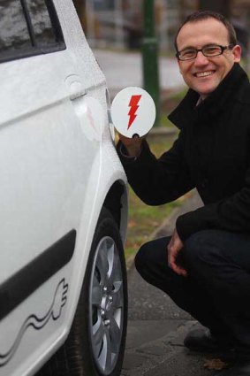 Greens candidate Adam Bandt with an electric car.