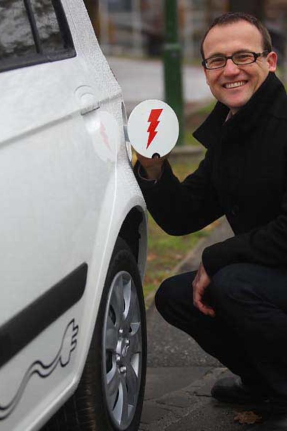 Greens candidate Adam Bandt with an electric car.
