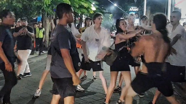 Schoolies push each other after one of the girls was hit in Bali.