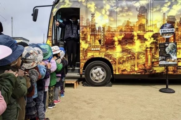 Children wait to enter Rumi Ozaki’s bus exhibit. 