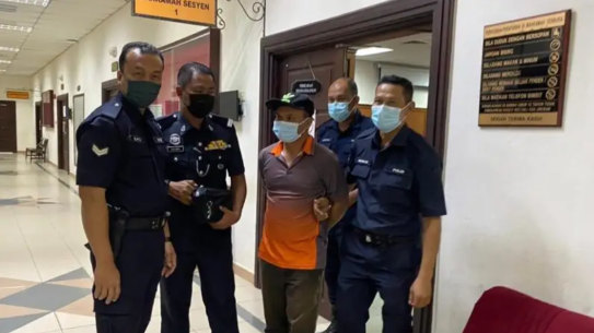 Alladin Lanim is escorted by Malaysian police during a court appearance in Kuching in August.
