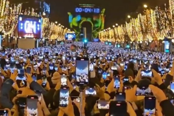 Revellers at the Arc de Triomphe in Paris on New Year’s Eve are too busy filming to celebrate the arrival of the new year.