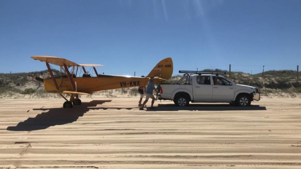 The vintage 1942 Tiger Moth was towed from the beach after avoiding campers to make a safe landing near Newcastle on Sunday morning.