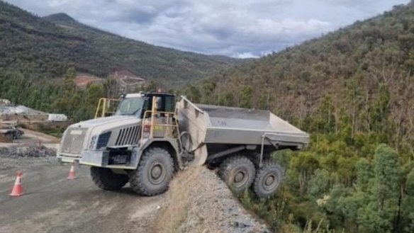 A truck known as a “moxy” teeters on the edge of a cliff after rolling down a road on the Snowy 2.0 project.