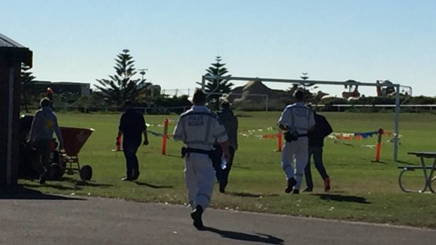 Mystery: Police and a camera crew head towards bushland near Corroba Oval, in Stockton, on Tuesday morning investigating the suspected murder of Steven Fenwick.