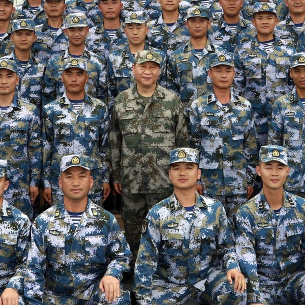 Xi Jinping (centre, in green military uniform) with members of the People’s Liberation Army (PLA) on a naval ship in the South China Sea in 2018.