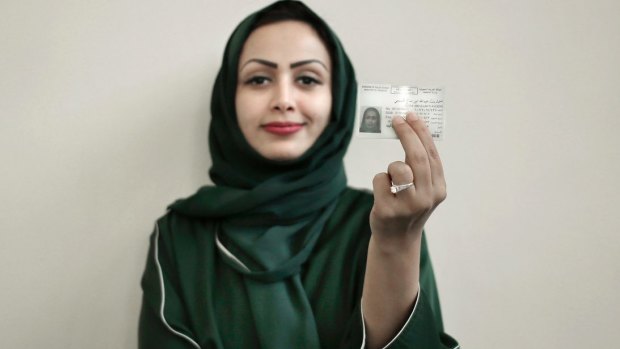 Asmaa al-Assdmi poses for a photograph holding her new car license at the Saudi Driving School inside Princess Nora University in Saudi Arabia.