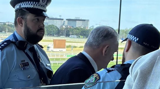 Mark Latham is escored out by police.