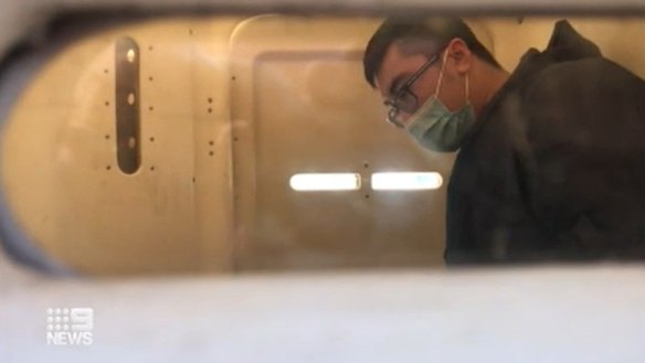 David Tran in police custody on Tuesday.