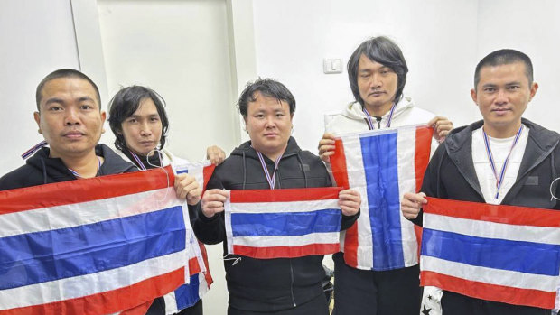 Freed Thai hostages, from left to right, Surasak Rumnao, Sathian Suwannakham, Bannawat Saethao, Watchara Sriaoun, and Pongsak Thaenna hold the Thai flag in Israel.