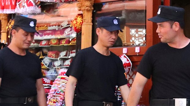 Police officers patrol at a street in Urmuqi, the capital city of the Xinjiang Uyghur Autonomous Region (XUAR), in northwestern People's Republic of China.