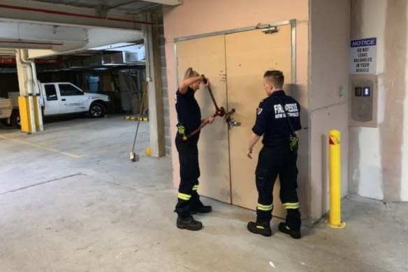 Firefighters use bolt cutters during an inspection of the Auburn apartment tower in late 2019.